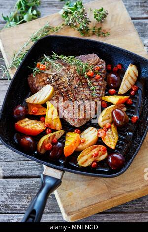 Ein T-Bone Steak wth glasierte Früchte und Kürbis in einer Grillpfanne Stockfoto