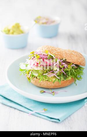 Ein Bagel mit Gurke, Avocado, Rettich und Radieschen Sprossen Stockfoto