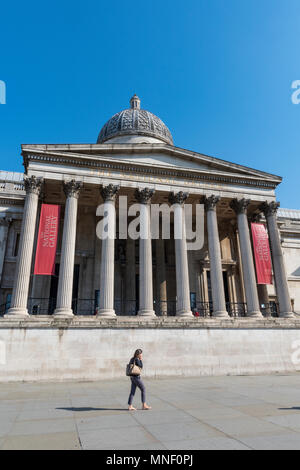 Eine junge Frau, die eine Tasche vorbei gehen. Die national gallery im Londoner Trafalgar Square an einem hellen und sunney Sommer Tag mit blauen Himmel Himmel. Stockfoto