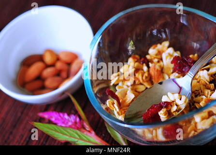 Schüssel Müsli mit Obst und Nüsse in der Schale und mit Löffel, Obst und Smoothie für gesundes Frühstück Mahlzeit platziert. Stockfoto