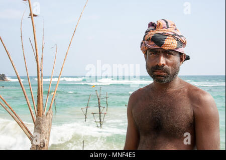 Portrait von lokalen Sri Lankan stelze Fischer, mit bluje Meer im Hintergrund Stockfoto