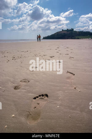 Junges Paar Spaziergänge auf einsamen Strand vor Llanstephan Schloss, Carmarthenshire Wales UK Stockfoto