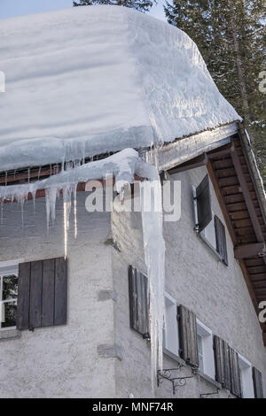 Schwere Schnee auf dem Dach mit Eiszapfen Stockfoto