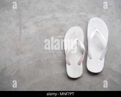 Aus weißem Gummi Sandalen Flip Flops auf Zement Hintergrund der Ansicht von Oben Stockfoto