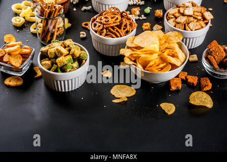 Variation verschiedener ungesunden Snacks Kekse, süßes Popcorn gesalzen, Tortillas, Muttern, Strohhalme, bretsels, zurück Tafel Platz kopieren Stockfoto