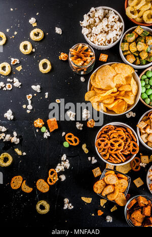 Variation verschiedener ungesunden Snacks Kekse, süßes Popcorn gesalzen, Tortillas, Muttern, Strohhalme, bretsels, zurück Tafel Platz kopieren Stockfoto