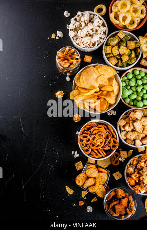 Variation verschiedener ungesunden Snacks Kekse, süßes Popcorn gesalzen, Tortillas, Muttern, Strohhalme, bretsels, zurück Tafel Platz kopieren Stockfoto