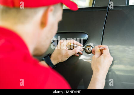 Schlosser Öffnen der Fahrzeugtür mit lockpicker Stockfoto