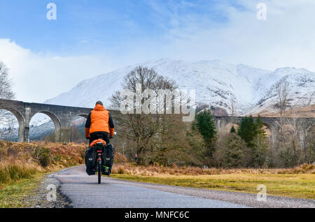 Man Radfahren (Radwandern) vor glenfinnan Viadukt, Schottland Stockfoto