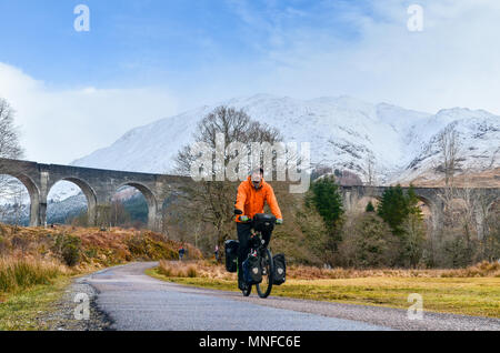 Man Radfahren (Radwandern) vor glenfinnan Viadukt, Schottland Stockfoto