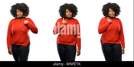 Junge schöne afrikanische Plus size Modell glücklich und überrascht jubelnden Ausdruck wow Geste und zeigt mit dem Finger auf weißem Hintergrund. Coll Stockfoto