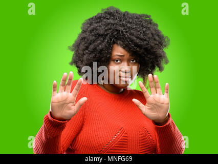 Schöne afrikanische Frau angewidert und wütend, halten die Hände in stop Geste, als Verteidigung, schreien Stockfoto