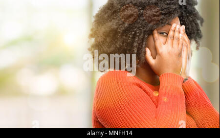 Schöne afrikanische Frau lächelnd in schüchtern schauen spähen durch ihre Finger, das Gesicht mit den Händen verwirrt im großen und ganzen suchen, Außenpool Stockfoto