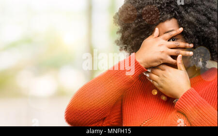 Schöne afrikanische Frau lächelnd in schüchtern schauen spähen durch ihre Finger, das Gesicht mit den Händen verwirrt im großen und ganzen suchen, Außenpool Stockfoto