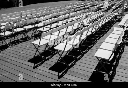 Reihen von weißen leeren Klappstühle in einem Sommer Theater. Stockfoto