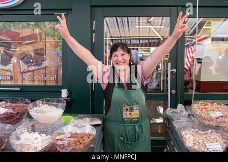 Eine glückliche Frau, die Süßigkeiten am Naschmarkt open air in Wien, Österreich verkauft. Stockfoto