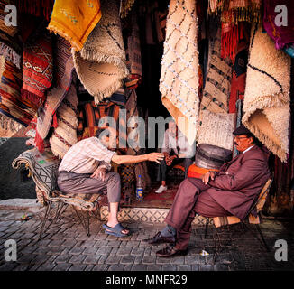 Marrakesch, Marokko, Juni 2016: Straßenhändler diskutieren vor ihren traditionellen Geschäften in der alten Medina Stockfoto