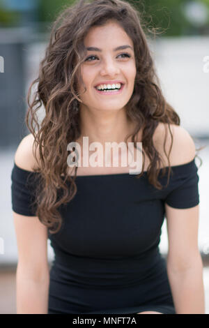 Mädchen sitzt auf der Bank und lächelnd Stockfoto