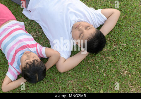 Bruder und Schwester schlafen auf grünem Gras, Ansicht von oben und gesundes Konzept Stockfoto