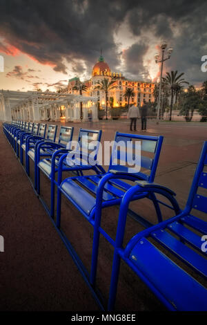Die berühmten blauen Stühlen vor dem Hotel Negresco an der Promenade des Anglais, Nizza, Frankreich bei Sonnenuntergang fotografiert. Stockfoto