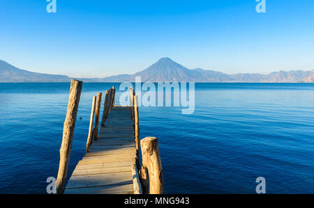 Holz- pier am Atitlan See am Strand in Panajachel, Guatemala. Mit schönen Landschaft der Vulkane Toliman, Atitlán und San Pedro in der Stockfoto