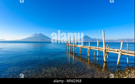Holz- pier am Atitlan See am Strand in Panajachel, Guatemala. Mit schönen Landschaft der Vulkane Toliman, Atitlán und San Pedro in der Stockfoto
