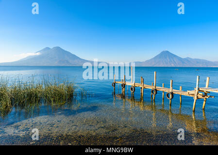 Holz- pier am Atitlan See, an der Küste bei Panajachel, Guatemala. Mit schönen Landschaft der Vulkane Toliman, Atitlán und San Pedro. Stockfoto