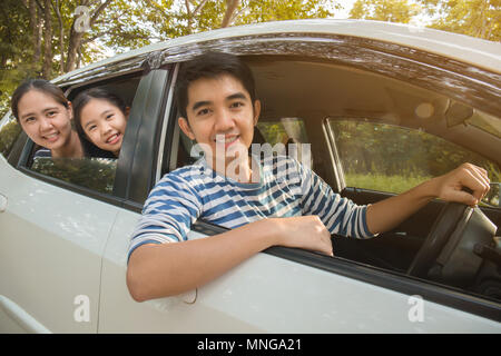 Gerne asiatische Familie auf Mini Van sind lächelnd und fahren für Reisen im Urlaub Stockfoto