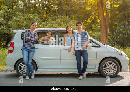 Gerne asiatische Familie auf Mini Van sind lächelnd und fahren für Reisen im Urlaub Stockfoto