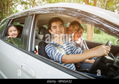 Gerne asiatische Familie auf Mini Van sind lächelnd und fahren für Reisen im Urlaub Stockfoto