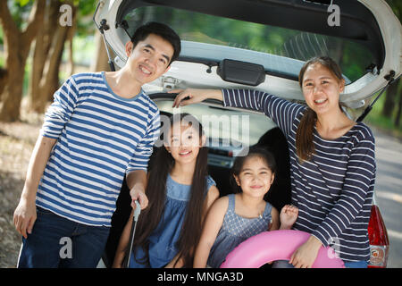 Gerne asiatische Familie auf Mini Van sind lächelnd und fahren für Reisen im Urlaub Stockfoto