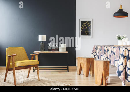 Elegante schwarze und weiße Home Interior im rustikalen Stil mit Designer Sessel und Holz- log Tischdecke Stockfoto