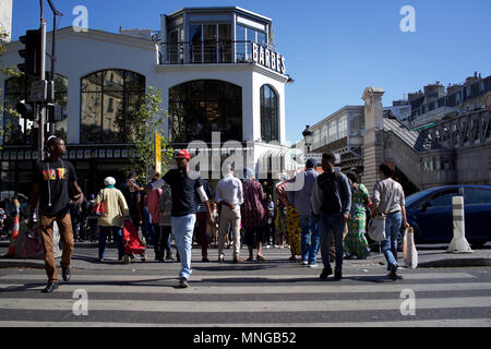 Einem geschäftigen Boulevard Barbès, Paris, Frankreich, mit Brasserie Barbes im Hintergrund - Menschen, die über die Straße Stockfoto