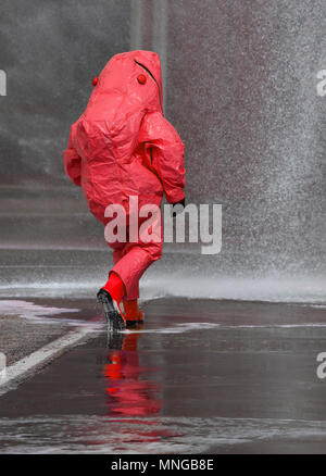 Feuerwehrmann mit roten Schutzausrüstung gegen biologische Risiken Stockfoto