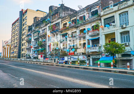 YANGON, MYANMAR - 16. FEBRUAR 2018: Die schäbigen Hochhäuser erstrecken sich entlang der Pansodan Street Bridge in der Innenstadt, am 16. Februar in Yangon. Stockfoto