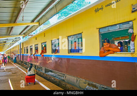 KYAIKTIYO, MYANMAR - Februar 16, 2018: Zahlreiche Passagiere von Yangon, Zug, dass bei Kyaiktiyo Bahnhof hält, in den Wagen sitzen am offenen Fenster Stockfoto