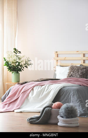 Kingsize-bett, modernes Schlafzimmer Innenraum mit Blumen auf dem Nachttisch Stockfoto