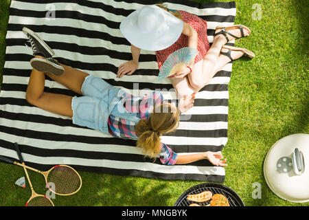 Frauen liegen auf Vertrag während Barbecue Party Stockfoto