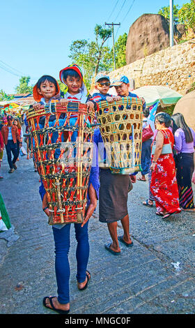 KYAIKTIYO, MYANMAR - Februar 16, 2018: Der lachende kleine Jungen darstellen, sitzen in Körbe Torhüter", Golden Rock Temple, am 16. Februar in Kyaiktiyo. Stockfoto