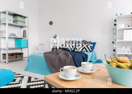 Schuss ein Gemütliches modernes Schlafzimmer mit blauen Verzierungen Stockfoto