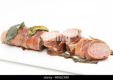 Ein Sattel Filet vom Reh reh Hyla arborea, dass in Prosciutto mit frischem Salbei Blätter von einem Supermarkt zwischen platziert gewickelt wurde. Stockfoto