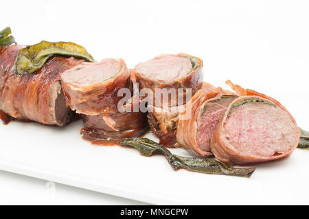 Ein Sattel Filet vom Reh reh Hyla arborea, dass in Prosciutto mit frischem Salbei Blätter von einem Supermarkt zwischen platziert gewickelt wurde. Stockfoto