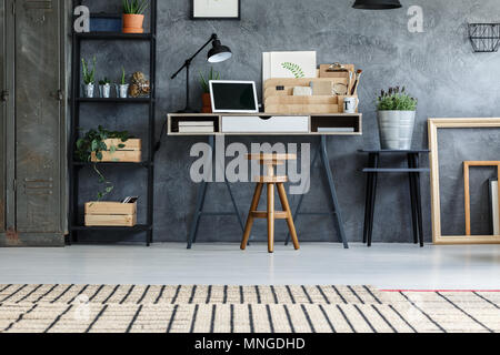 Graue Wand in hipster Büro mit moderner Arbeitsplatz Innenraum Stockfoto