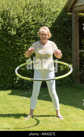 Frau mit einem Hula-Hoop-Reifen in einem Garten zu üben Stockfoto