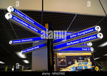 Wegweiser in der Abflughalle am Flughafen Schiphol in Amsterdam, Niederlande, Angabe der Richtung von Geschäften. Stockfoto