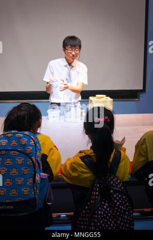 Museum Science Moderator im Gespräch mit der Chinesischen Schule Kinder im China Museum für Wissenschaft und Technologie in Peking, China. Stockfoto