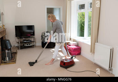 Home Umzüge, Frau mit einem Staubsauger den Teppich zu Hoover, bevor Sie aus dem Haus. Stockfoto