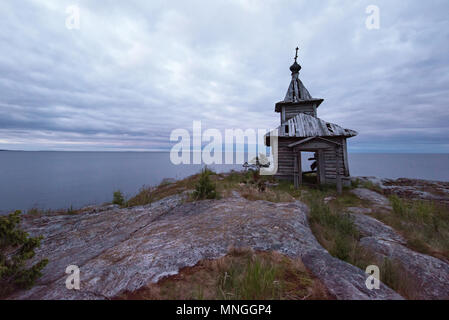 Landschaft mit verlassenen Kirche aus Holz auf einsamen felsigen Klippen. Trübes Wetter. Platz für Text. Stockfoto