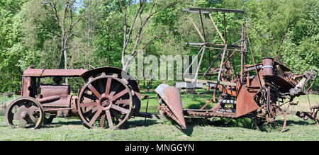 Rusty vintage kleine ländliche keinen Namen Traktor und gezogene antechnical Maschinen. Die Ausstattung ist mehr als vor hundert Jahren. Masse producti Stockfoto