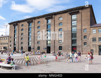 Menschen spielen im Wasser Brunnen außerhalb der sanierten Getreidespeicher in King's Cross. Stockfoto